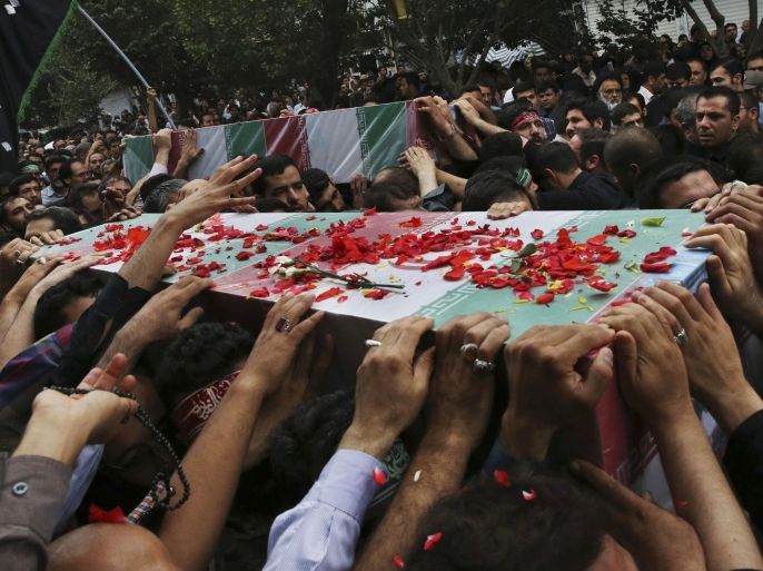 Iranian mourners the carry flag draped coffins of Ali Amraei and Hassan Ghaffari, who were killed in fighting against Islamic State extremists in Syria, during a funeral ceremony in Shahr-e-Ray south of Tehran, Iran, Thursday, June 25, 2015. Iranian state media say thousands of people have attended the funerals for eight Iranian volunteers killed in fighting against Islamic State extremists in Syria. Thursday's report by the official IRNA news agency says three of the volunteers were buried in the capital, Tehran, and the rest in the northeastern city of Mashhad. (AP Photo/Vahid Salemi)