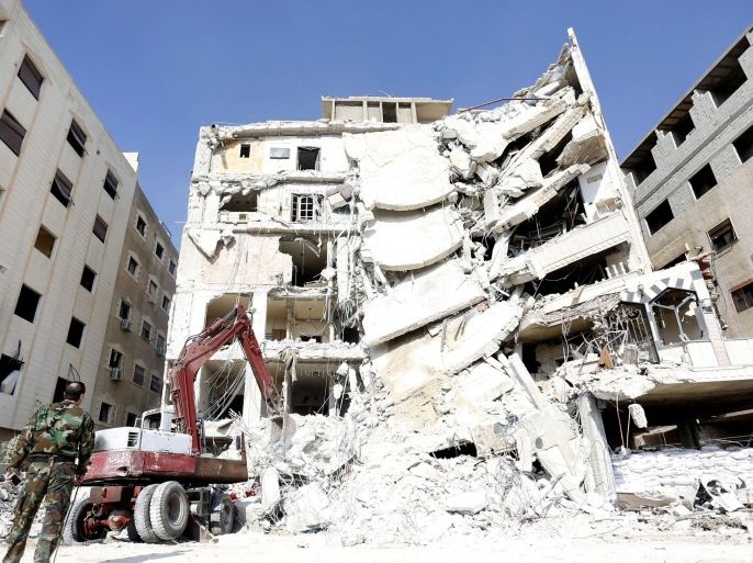 A soldier stands as a crane lifts wreckage of a residential building following an air strike in which Hezbollah member Samir al-Qantar was killed, in the south of Jaramana city, Damascus countryside, Syria, 20 December 2015. Lebanese Shiite militia of Hezbollah said on 20 December that Samir Qantar, who became a Hezbollah member after he was jailed in Israel for a deadly 1979 raid, was assassinated in an Israeli airstrike on the outskirts of the Syrian capital of Damascus.