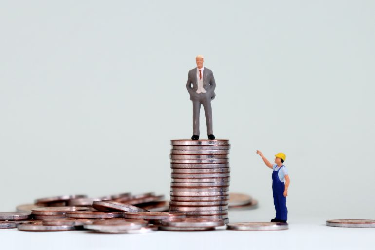 An economic gap concept. A pile of coins and miniature people.; Shutterstock ID 1088213336; purchase_order: AJA; job: ; client: ; other: