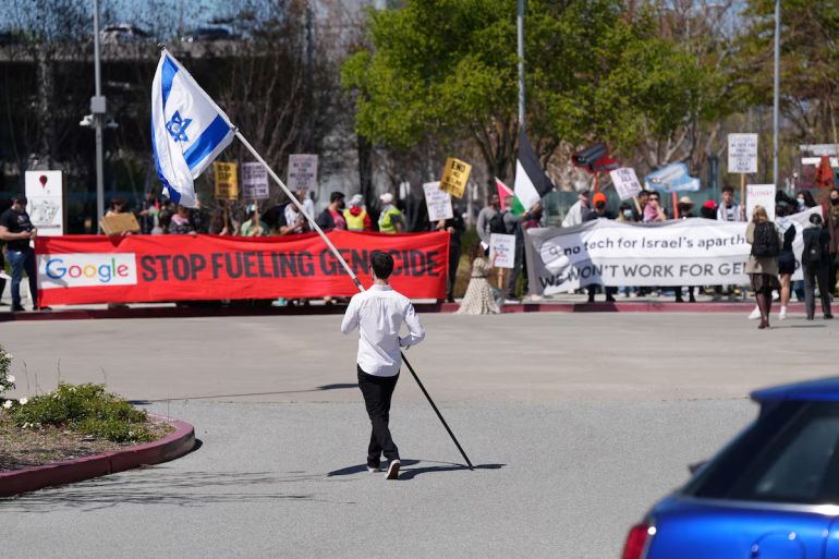 A counter-protester holding an Israeli flag walks into the parking lot near a protest at Google Cloud offices in Sunnyvale, California, U.S. on April 16, 2024. REUTERS/Nathan Frandino/File Photo Purchase Licensing Rights